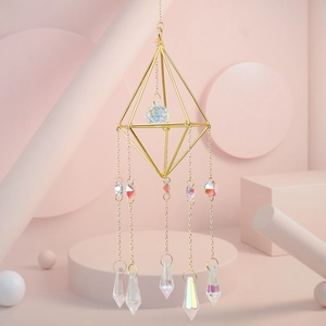 Detail of golden geometric crystal suncatcher with rainbow prisms and faceted sphere