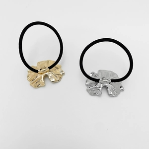 Detailed close-up of gold and silver leaf-shaped alloy hair ties with black elastic bands