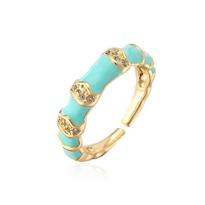 Detailed macro of gold bamboo open ring with teal enamel and shimmering zircons