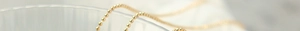 Detailed close-up of the 18K gold-plated beaded ball chain texture and metallic luster