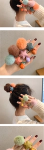 Dettaglio di elastici per capelli in peluche con pompon colorati e stelle in resina