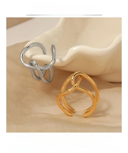 Détail de bagues torsadées argent et or sur un élégant support en soie et céramique