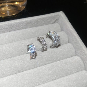 Macro shot of silver ear cuffs set with sparkling zircons in a velvet jewelry box