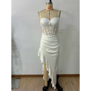 Detail of white corset dress with 3D butterfly appliques and ruffled irregular hemline