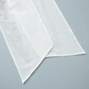 Detailed macro view of white breathable linen blend fabric with precise edge stitching