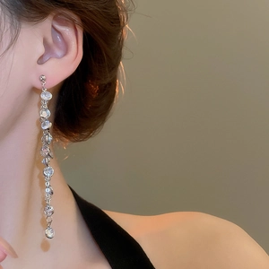 Model wearing silver long tassel earrings with sparkling round cubic zirconia stones
