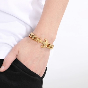 Close-up of men's gold anchor link bracelet on wrist with punk vintage aesthetic