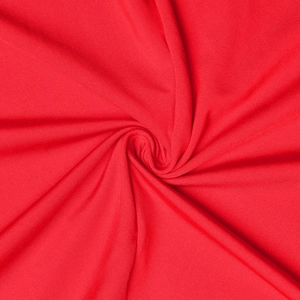 Gros plan du tissu rouge de la robe montrant la texture détaillée et la qualité du textile