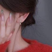 Dettaglio dell'orecchino a cerchio in argento con ciondolo indossato dalla modella