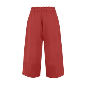Detail view of red linen wide-leg trousers featuring elastic waistband and drawstring