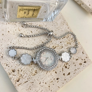 Close-up of women's flower bracelet watch with mother of pearl dial and rhinestone bezel