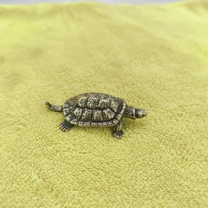 Handcrafted vintage brass turtle figurine with detailed shell texture on a bright background