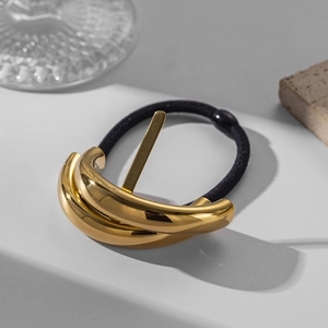 Detail of high-end golden metal buckle on black elastic hair tie with modern props