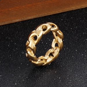 Macro shot of gold-plated chain link ring showing intricate metal texture on dark surface