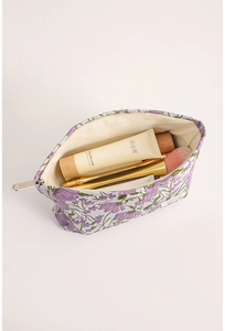Close-up of purple floral embroidery on canvas makeup bag with spacious interior compartment