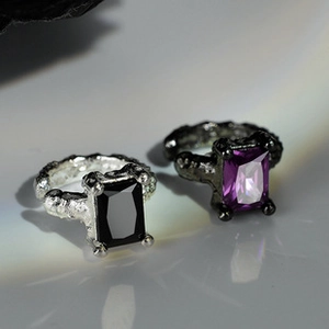Macro shot of irregular lava texture rings with rectangle black and purple gems