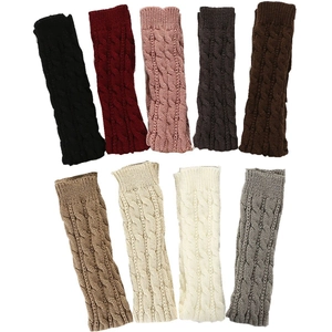 Detailed view of long cable-knit fingerless gloves in nine various colors on plain background