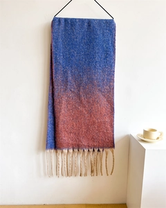 Detail of blue and red gradient pashmina shawl with soft beige fringe and wool texture