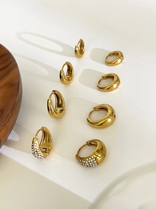 Vue détaillée de boucles d'oreilles gouttes dorées avec finition lisse et zircons