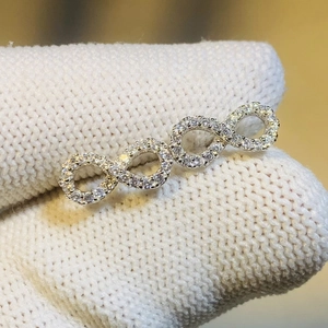 Macro view of infinity symbol earrings with silver plating and pavé white zircons
