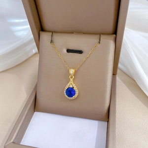 Detailed view of water drop blue gemstone necklace with crystals in a beige jewelry gift box
