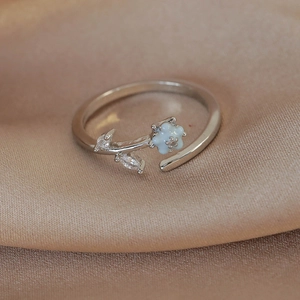 Detailed macro view of silver flower open ring with blue petals and marquise zircon accents