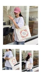 Detail view showing printed floral wreath and happy everyday slogan on beige canvas tote