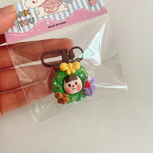 Gros plan d'un porte-clés couronne de Noël avec une fille mignonne et un ours