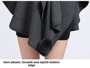 Detail of dark grey knit poncho featuring faux rabbit fur pom-poms and smooth hemline