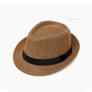 Close-up detail of khaki woven straw sun hat with black matte ribbon and fine texture