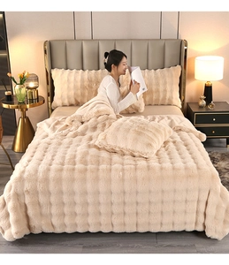 Detail of beige faux rabbit fur blanket featuring a thick 3D checkered plush texture