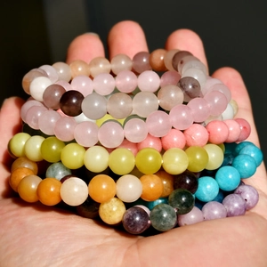 Vibrant 8mm natural stone beaded bracelets held in hand, colorful friendship jewelry gift