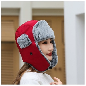Detail of red winter trapper hat with soft gray faux fur lining and ear protection flaps