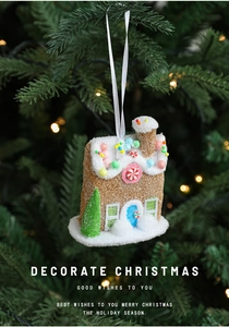 Close-up of a gingerbread house ornament hanging on a Christmas tree with warm lights