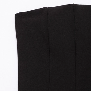 Close-up of black textured fabric and seam detail on a wave-hem off-shoulder mini dress