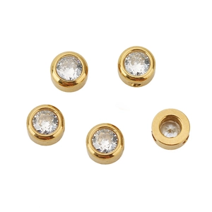 Close-up of five gold plated cylinder beads with inlaid cubic zirconia crystals