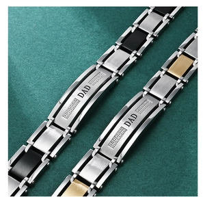 Close-up of DAD engraved stainless steel bracelets with two-tone links and diamond inlay