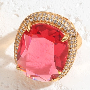 Macro view of a 14K gold plated ring featuring a large pink gemstone and pavé zircons