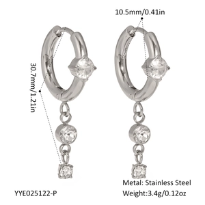 Macro detail of silver stainless steel hoop earrings with three cubic zirconia stones