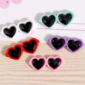 Detailed view of colorful mini heart-shaped sunglasses for DIY crafts and doll decoration