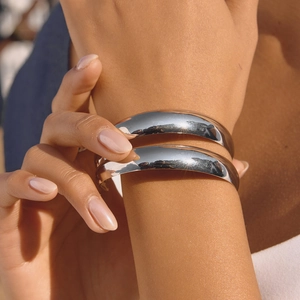 Polished silver stainless steel chunky open cuff bracelets worn in a stacked style