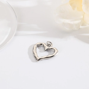 Close-up of irregular silver heart pendant with polished finish and connector ring