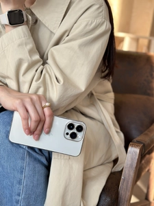 Chic off-white matte iPhone case held by a person in a retro leather setting