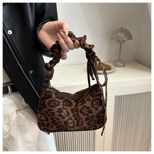 Detail of trendy leopard print handbag featuring a ruched cloud-style handle and top zipper