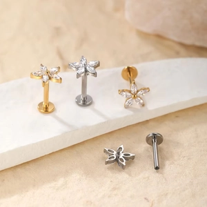 Macro detail of G23 titanium flower labret studs with cubic zirconia in gold and silver
