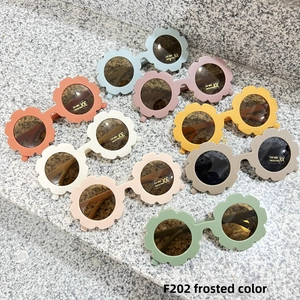 Detailed view of matte flower-shaped sunglasses for kids with UV 400 protection labels