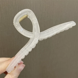Detalle de la estructura aerodinámica de la pinza para el cabello blanca translúcida