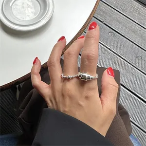 Detail of silver S925 sterling silver croissant and beaded stackable rings on finger