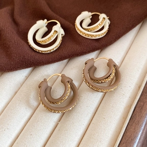 Detail of double-layer 18k gold-plated hoops in cream white and mocha brown enamel