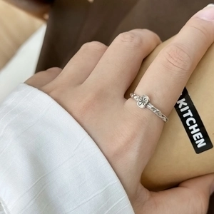 Minimalist silver lava texture ring with star motif and woven band on model's hand